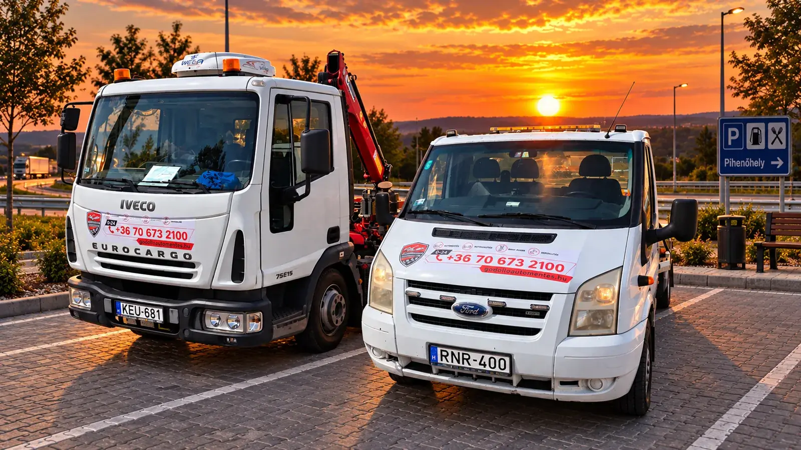 Két saját autómentőnk, a darus Iveco és a platós Ford, naplementében